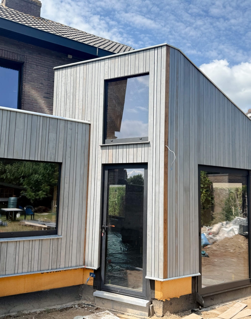 Detail van ayous gevelbekleding met glaspartijen, hoekige aanbouw door Bosk Houtbouw