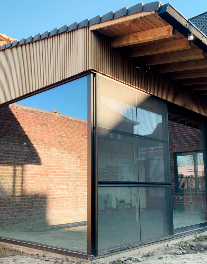 Moderne aanbouw in houtskeletbouw met hoekbeglazing en verticale houten gevelbekleding