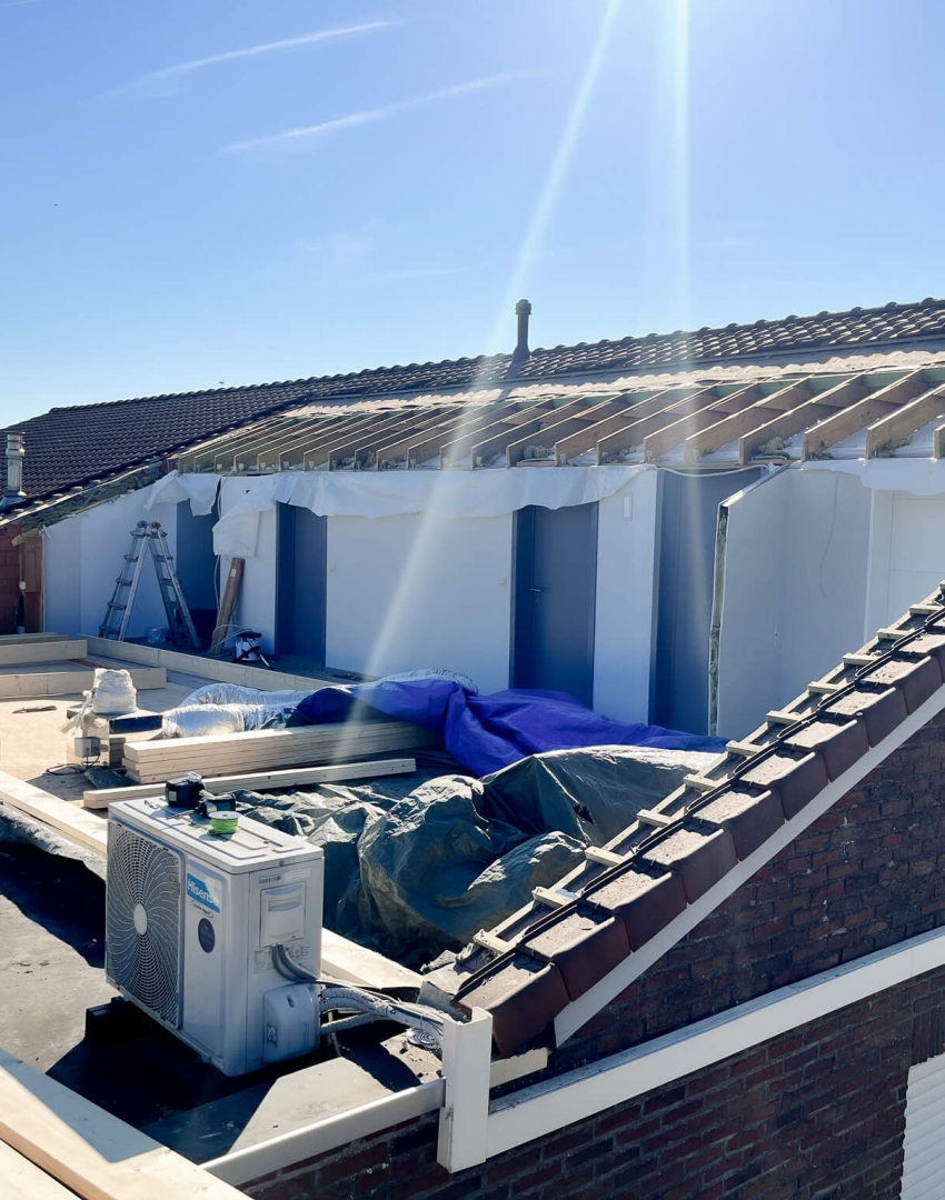 Opbouw van platte dakconstructie naast hellend dak met dakkapel