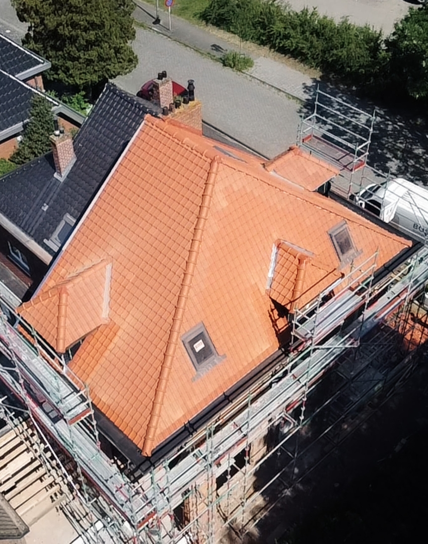 Luchtfoto van volledige dakrenovatie met nieuwe dakpannen en dakkapellen door Bosk Houtbouw