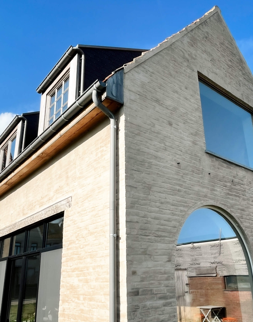 Rond venster en boogvormige opening in vernieuwde gevel na totaalrenovatie